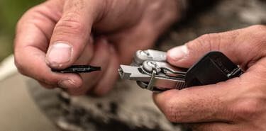 Outdoorsmen switching the bit in Leatherman Wave multi-tool.