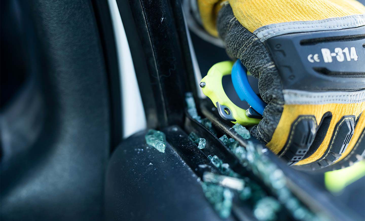 Person using Raptor Rescue glass breaker to break a car window.