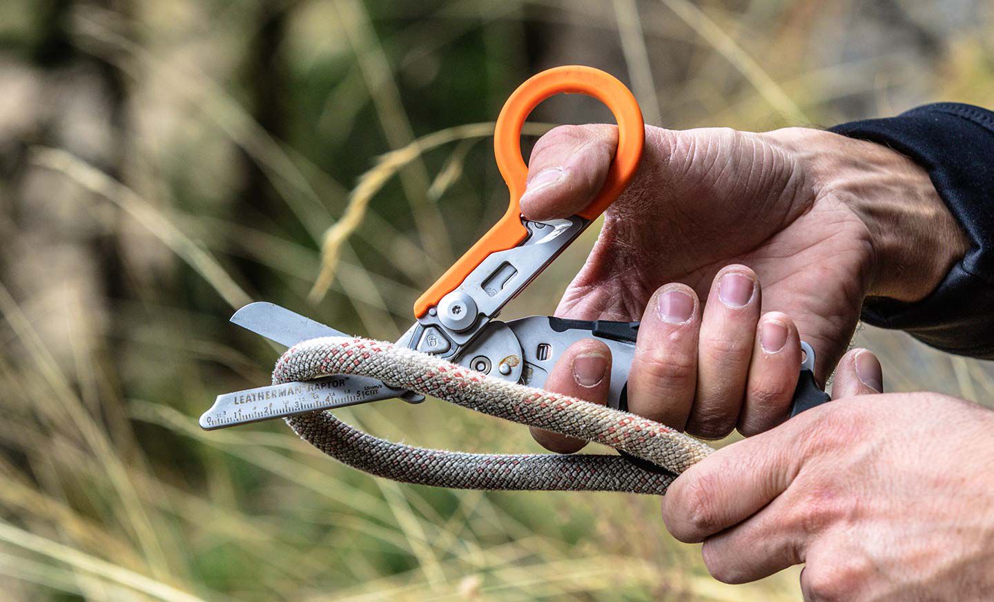 Person using Raptor Rescue shears to cut a thick rope.