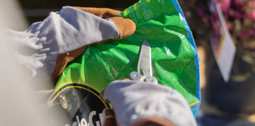 Leatherman opening a bag of soil