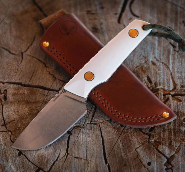 Malloy Special fixed knife and leather sheath on a stump