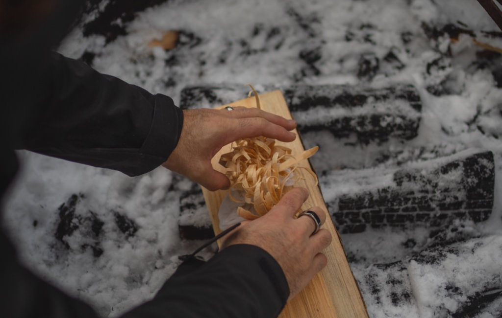 Kindling being placed on a log to light