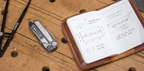 A Leatherman on a workbench with a notebook