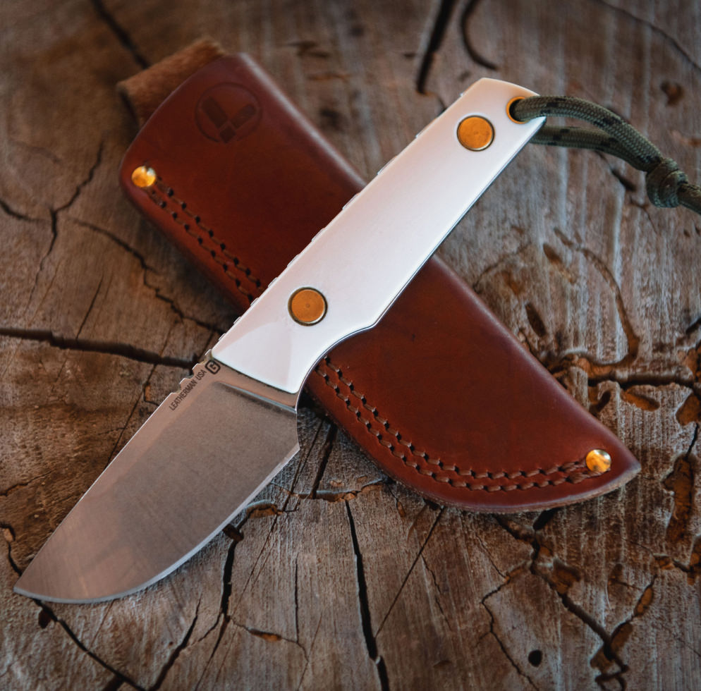 Malloy Special fixed knife and leather sheath on a stump