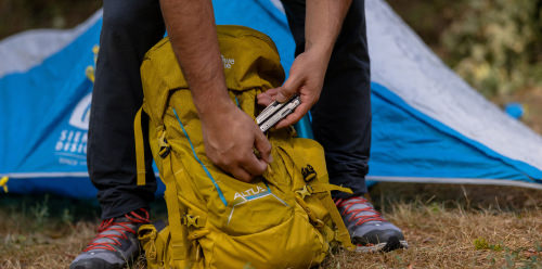 Hand putting a Leatherman Arc in a camping bag