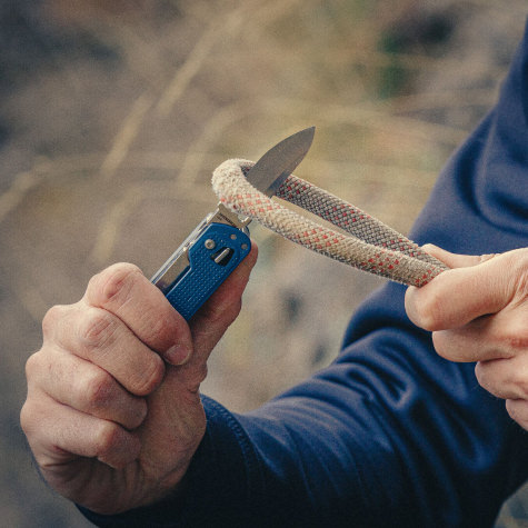 Opened knife of Free T4 cutting through rope