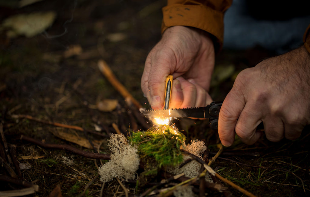 Signal Saw being used to light a fire with the ferro rod accessory