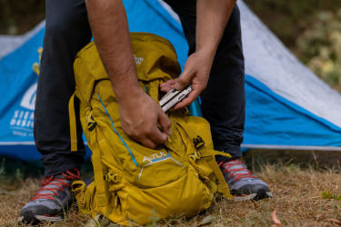 Hand putting a Leatherman Arc in a camping bag