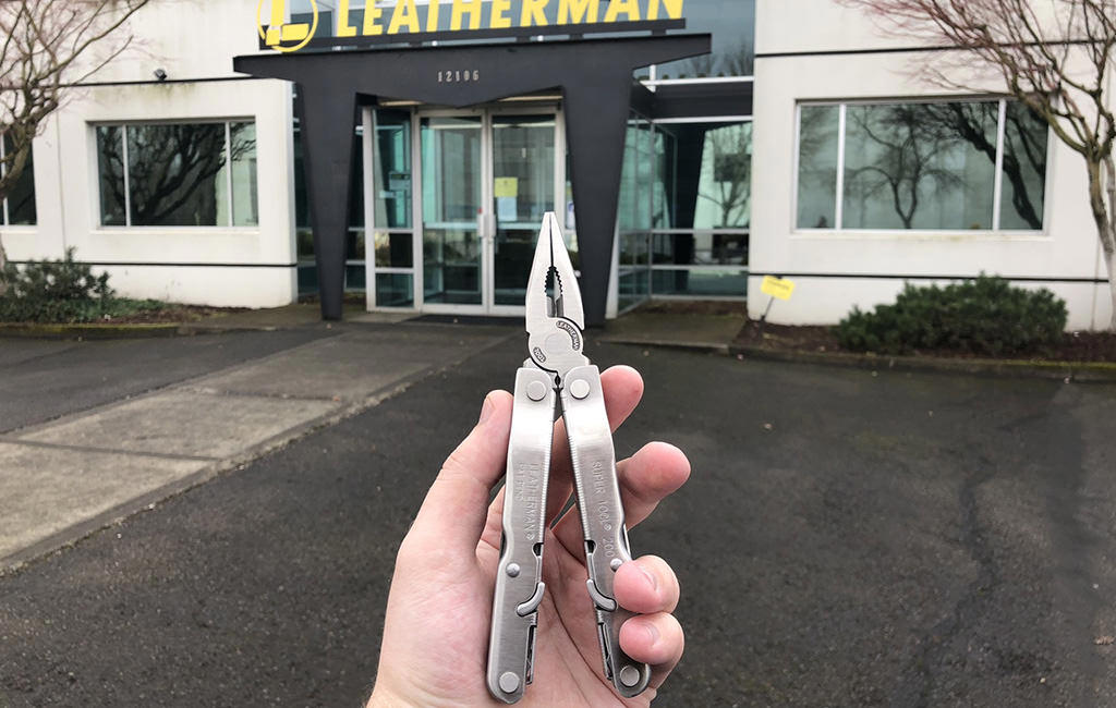 Hand holding a Leatherman Supertool at the facade of Leatherman factory.