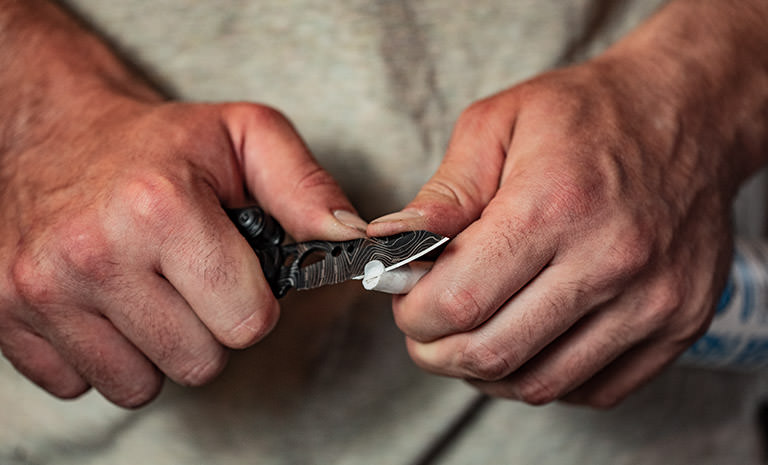 Leatherman freestyle multi-tool, black and silver topo print, knife blade cutting caulk tube